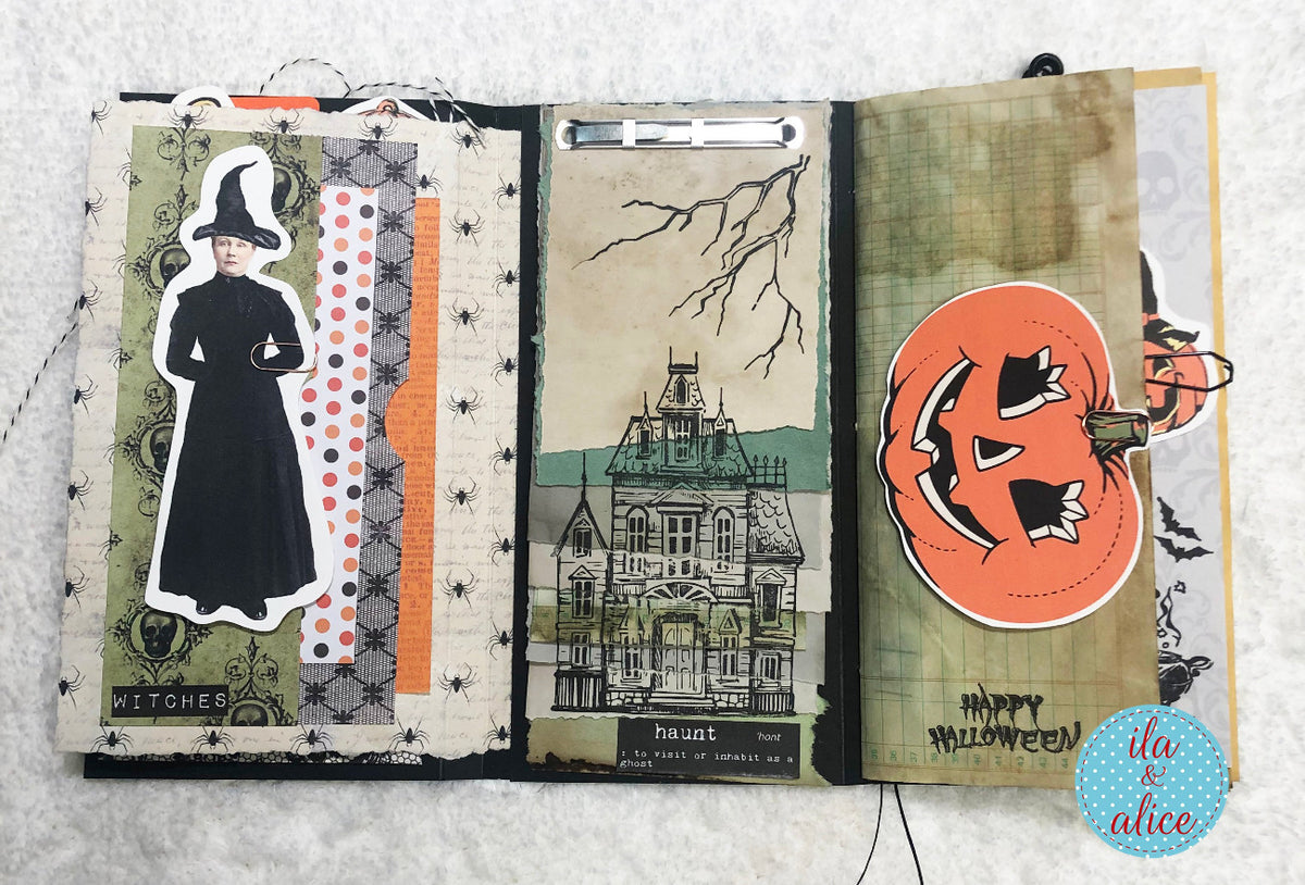Open Halloween-themed folio with decorative elements on a textured surface