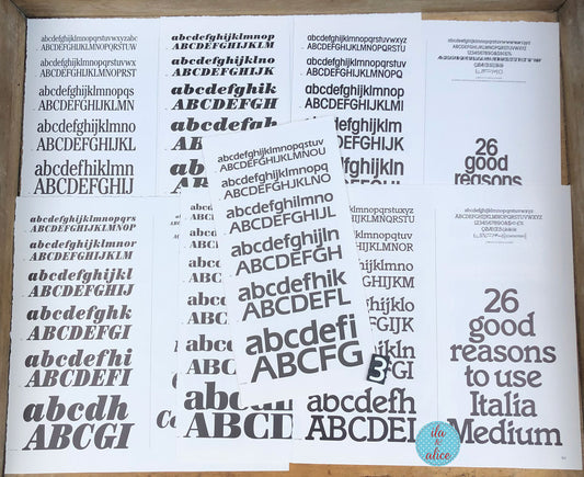 Several white book pages scattered on a white background, each printed with repeated black uppercase and lowercase alphabet lettering in varying font styles. A small circular logo in the bottom-right corner reads 'ila and alice'. and mixed-case lettering, along with the phrase '26 good reasons to use Italia Medium'.