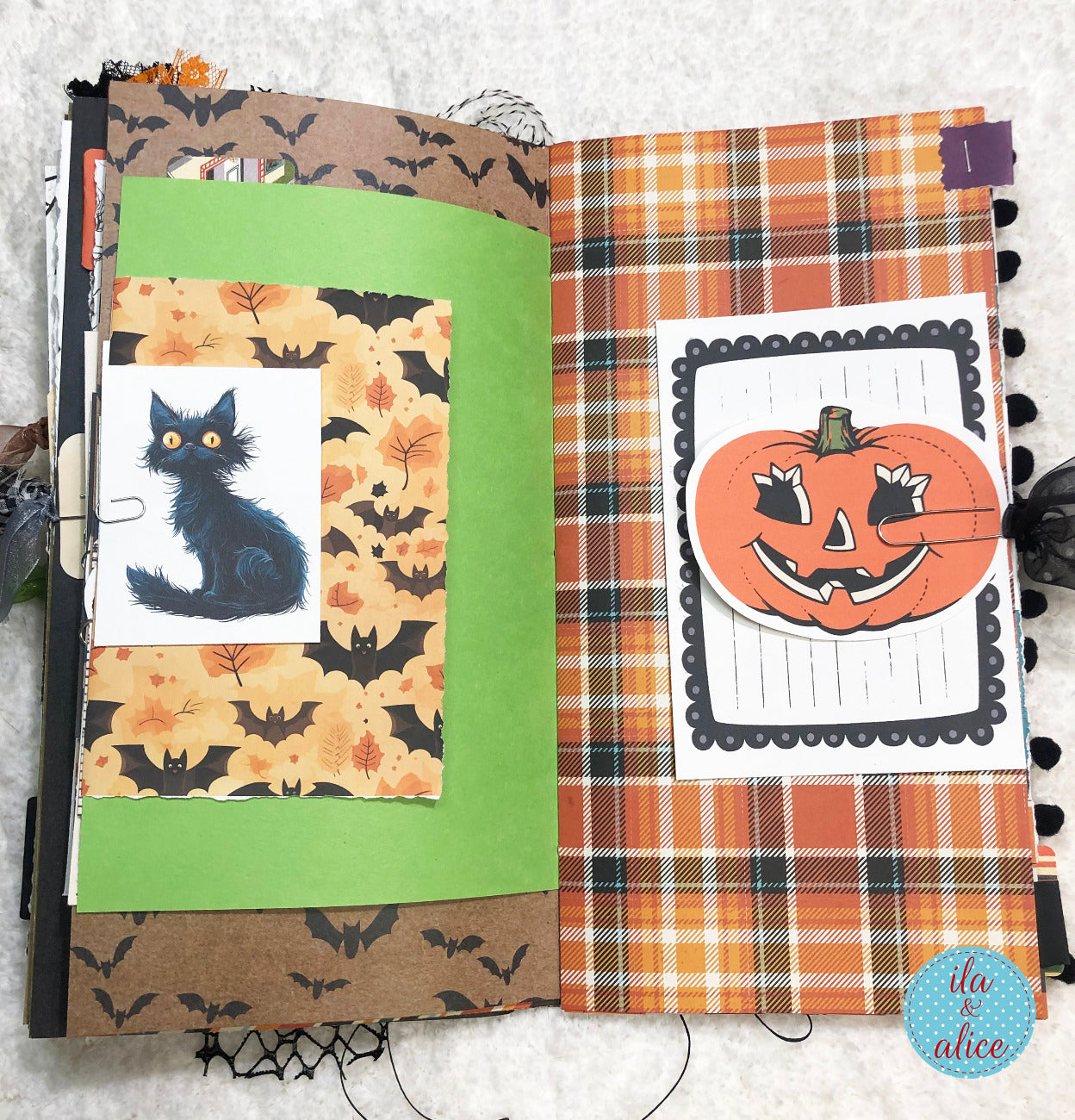 Handmade made Halloween junk journal  with black cat and pumpkin designs on a textured surface.