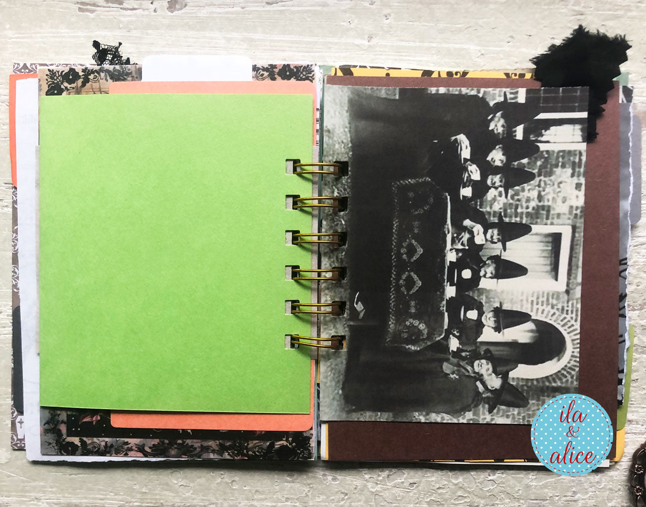 An open handmade spiral-bound scrapbook journal or notebook on a light wood background. The left page has a large blank lime green cardstock panel with patterned paper borders.