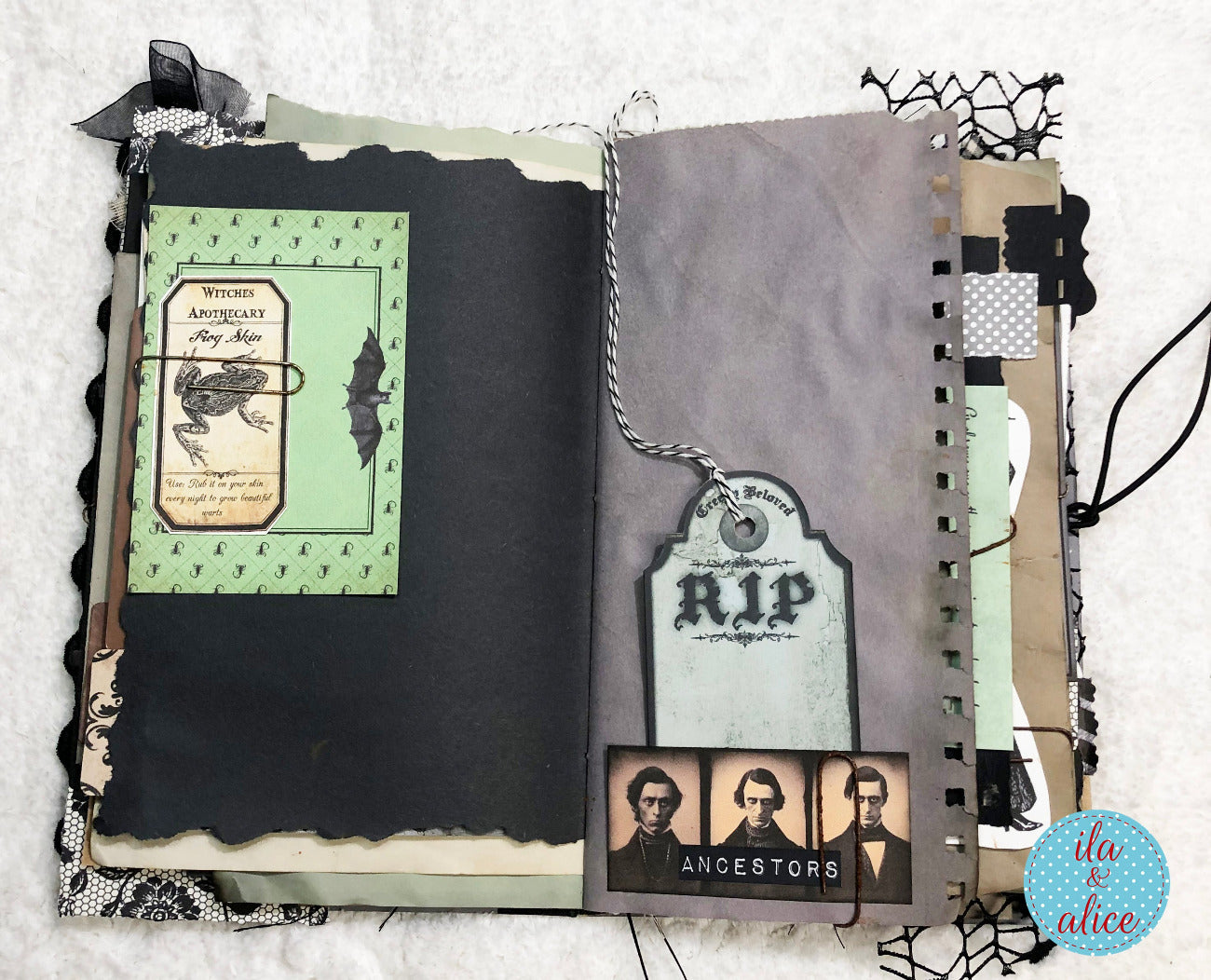 A handmade scrapbook journal featuring gothic and Halloween themes, with layered pages in black, gray, and pale green, embellished with lace, ribbons, a hanging tombstone tag, and an 'Ancestors' portrait collage.
