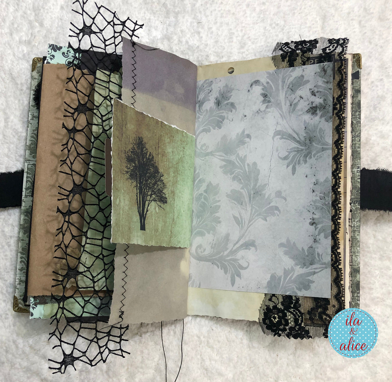 Handmade Eerie Halloween Gothic junk journal  with textured papers and decorative elements on a textured surface.