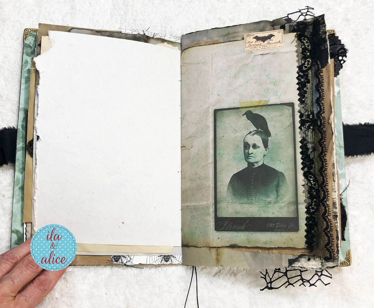 Handmade Eerie Halloween Gothic junk journal  w vintage photo album with an old portrait inside, held by a hand.