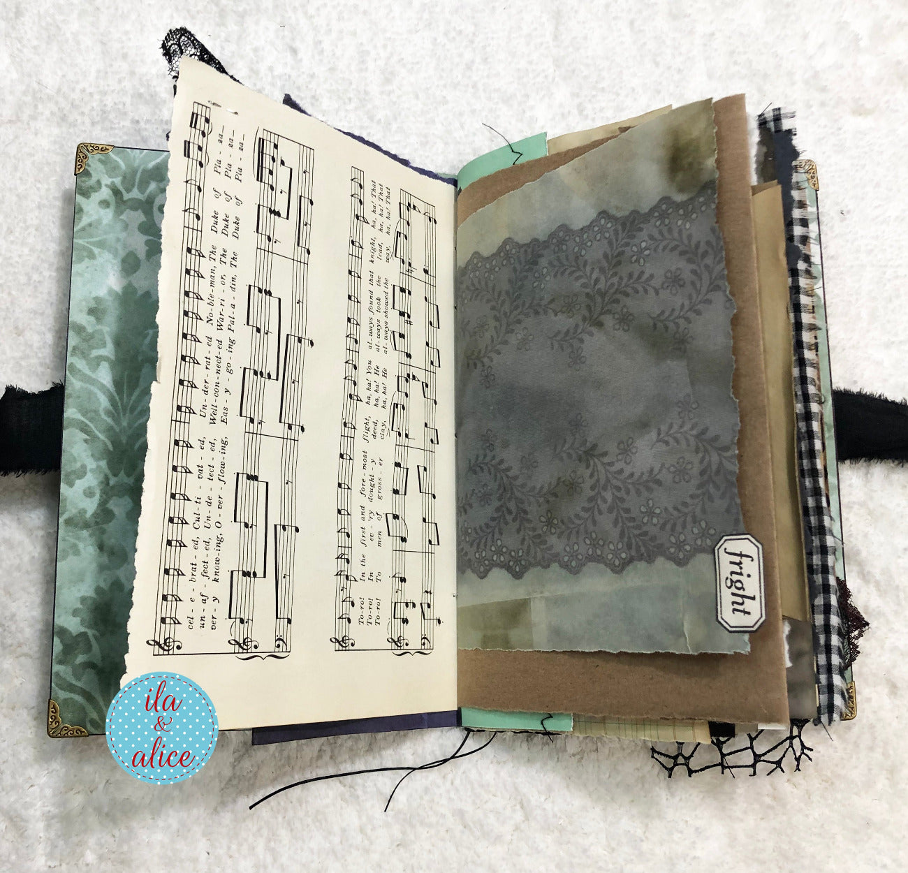 Handmade Eerie Halloween Gothic junk journal  with music sheet and decorative pages on a textured surface