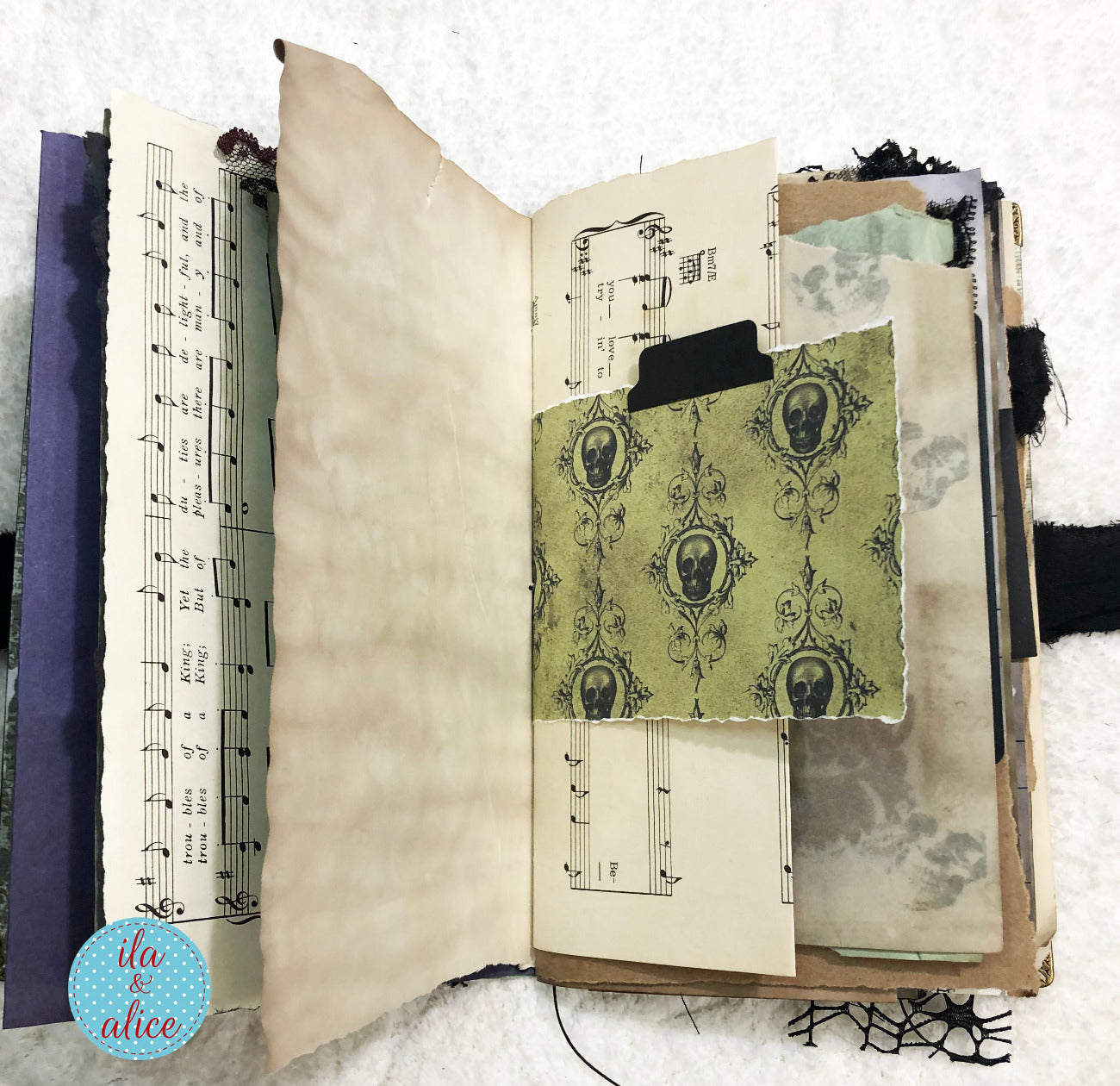 Handmade Eerie Halloween Gothic junk journal  with vintage-style pages including sheet music and decorative text.