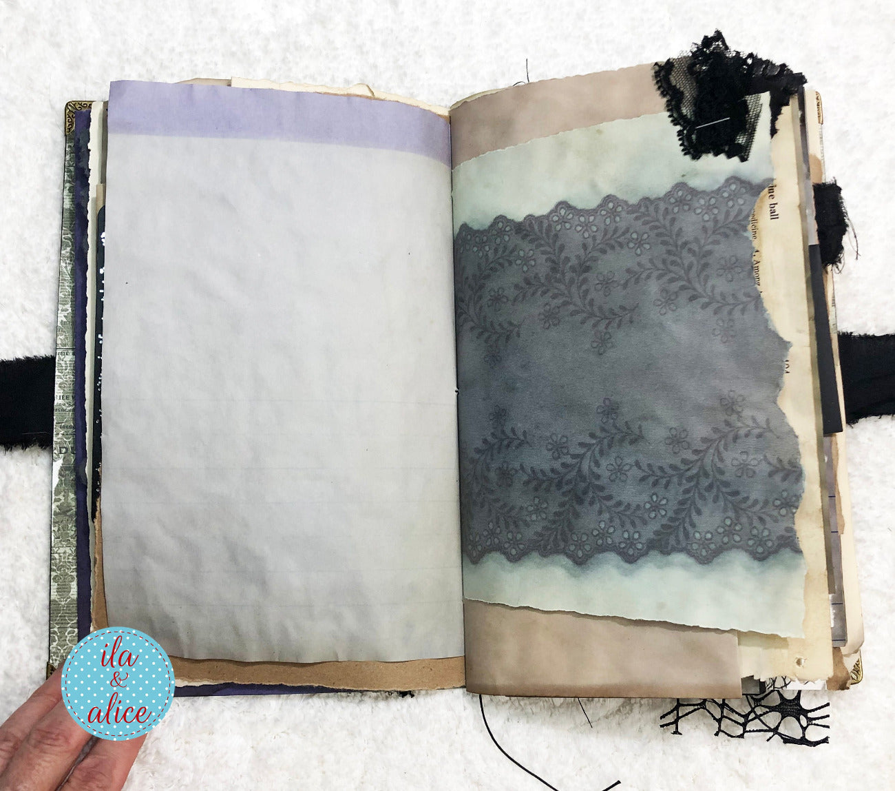 Handmade Eerie Halloween Gothic junk journal  with decorative pages featuring lace and fabric textures, held by a hand.