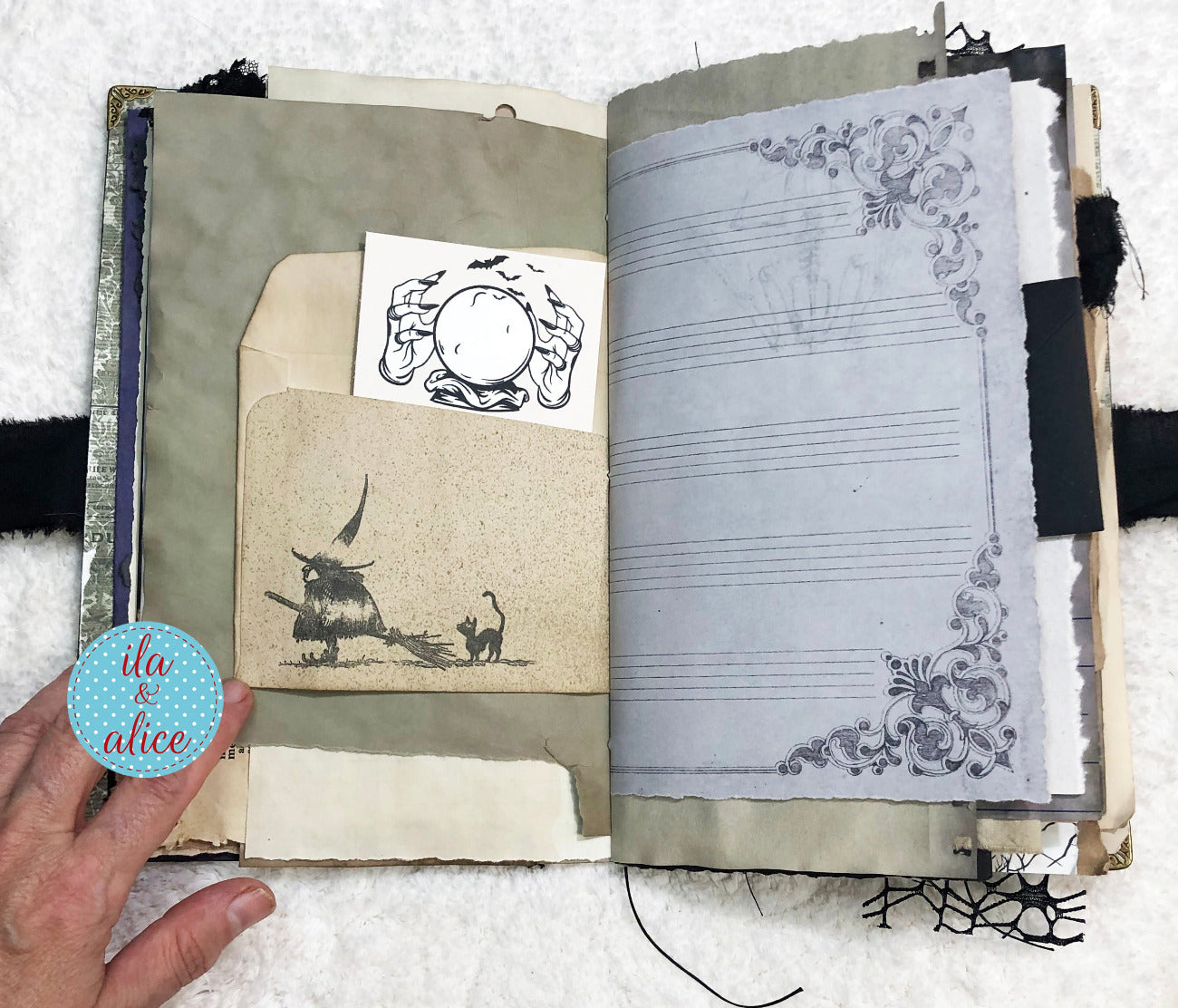 Handmade Eerie Halloween Gothic junk journal  with decorative pages and a hand holding a small round object.
