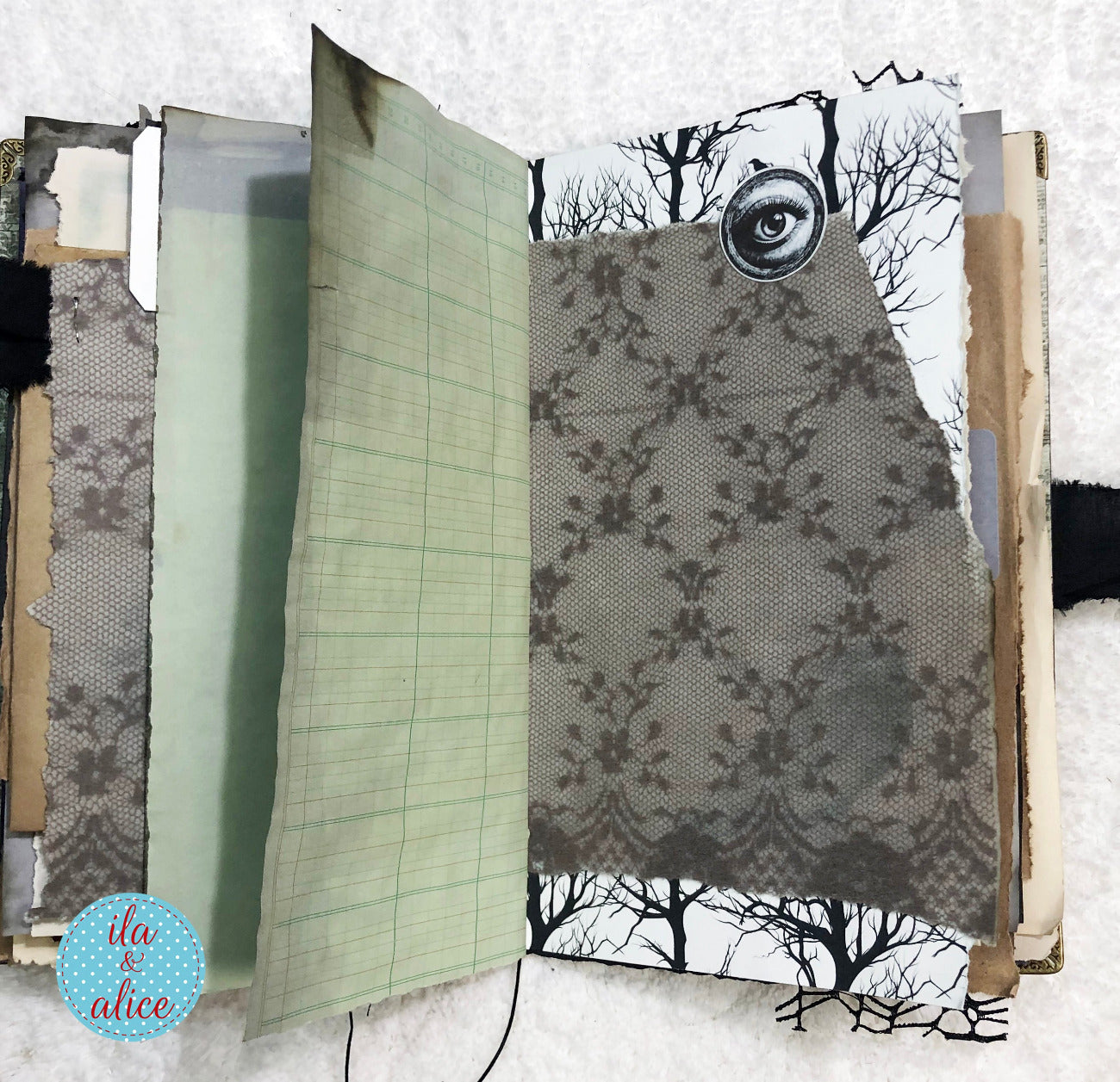 Handmade Eerie Halloween Gothic junk journal  w collage of patterned paper with a tree and eye design on a white background