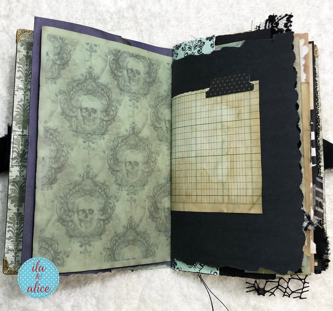 Handmade Eerie Halloween Gothic junk journal  with decorative pages and grid paper on a textured surface.