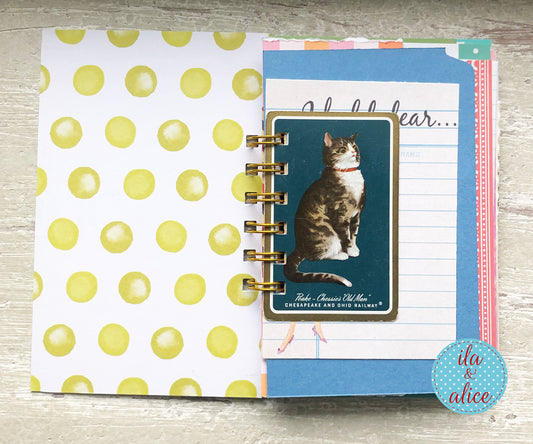 Planner with a cat illustration on a wooden surface