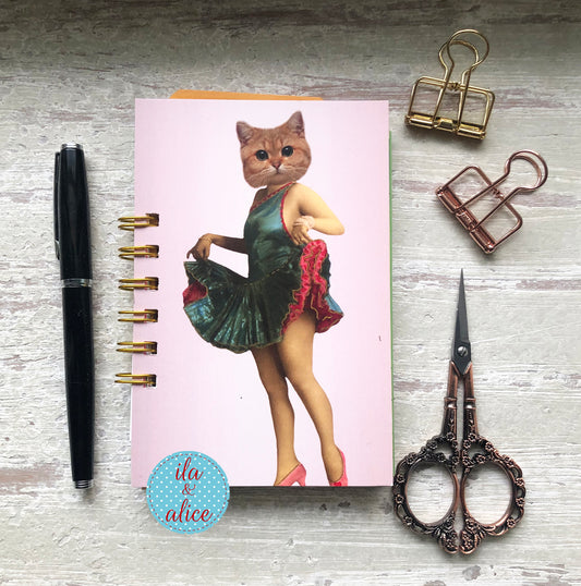 Mini handmade junk journal with vintage dancer body and cat face collage on pink background, spiral bound notebook