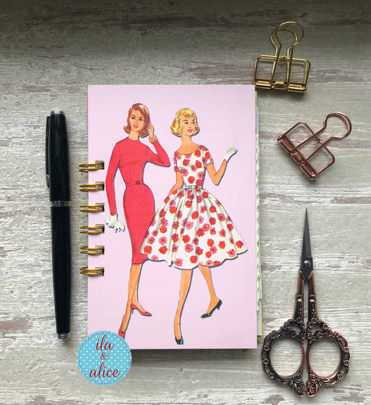 Mini handmade junk journal with vintage fashion illustration of women in pink and floral dresses, spiral bound notebook