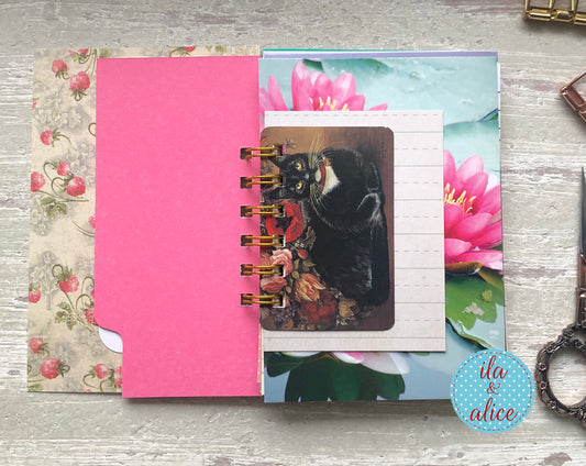 Notebook with floral and cat design on a wooden surface