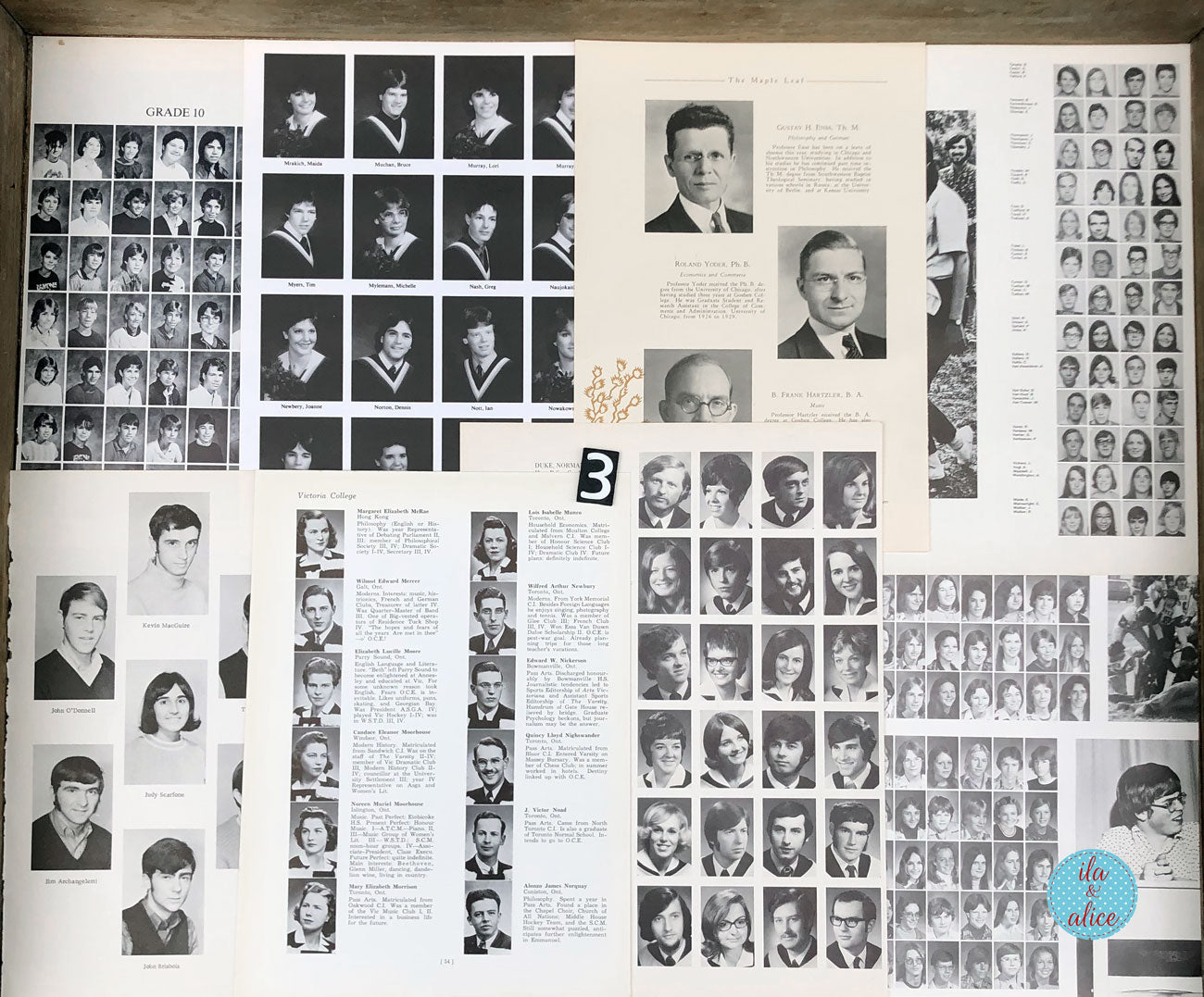 An open vintage yearbook spread showing multiple black-and-white portrait photo grids, name columns, and printed text pages laid flat on a wooden surface.