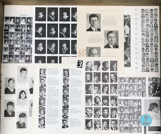 An open vintage yearbook spread showing multiple black-and-white portrait photo grids, name columns, and printed text pages laid flat on a wooden surface.